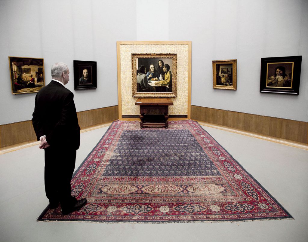 TO GO WITH AFP STORY BY MARIETTE LE ROUX Recent picture of a visitor looking at the painting Christ and Disciples of Emmaus (C) and other paintings by Han van Meegeren (1889-1947), on May 11, 2010 in the Boijmans Van Beuningen Museum in Rotterdam. Seven decades after duping the art world into embracing a fake as "the masterpiece" of Johannes Vermeer, its creator now has his own exhibition in a Dutch museum he once conned out of a small fortune. Entitled "Van Meegeren's Fake Vermeers", it showcases some of the forgeries Van Meegeren sold before he died aged 58 in 1947, test canvasses found in his studio and some of the ingenious forging methods he used. AFP PHOTO ANP ROBIN UTRECHT **NETHERLANDS OUT BELGIUM-OUT **