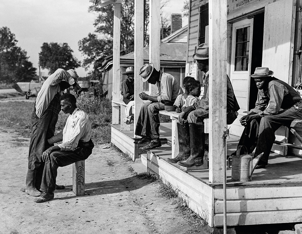 Marion Post Walcott: Haircutting in Front of General Store and Post Office on Marcella Plantation, Mileston, Mississippi, 1939 Forrás: The Metropolitan Museum of Art